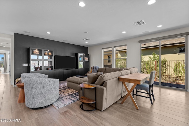 living room featuring light wood-style floors, recessed lighting, and visible vents