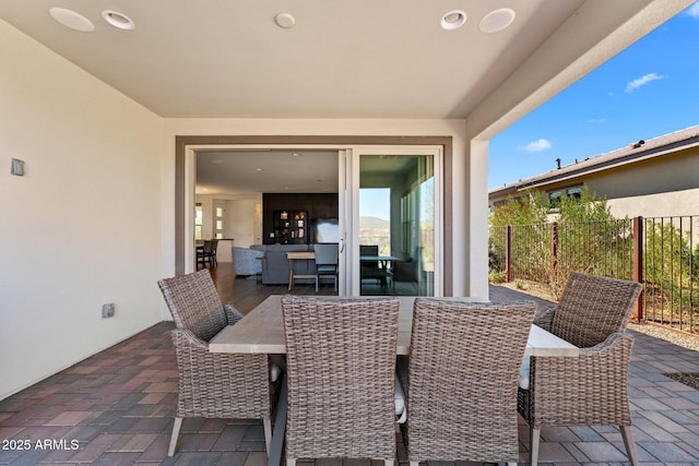 view of patio with outdoor dining space and fence