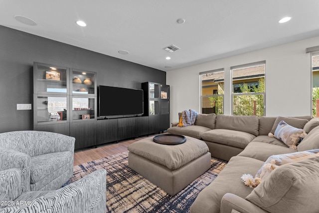 living area featuring recessed lighting, visible vents, and wood finished floors