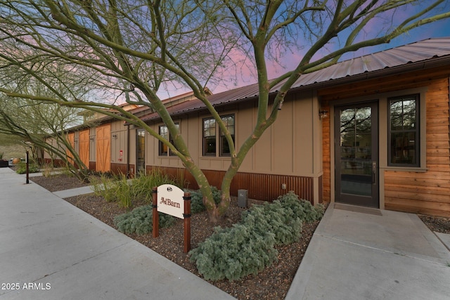 exterior entry at dusk with metal roof and board and batten siding