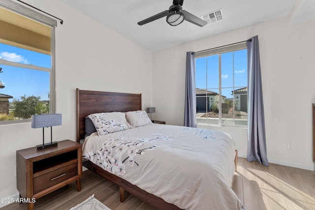 bedroom featuring multiple windows, wood finished floors, and visible vents