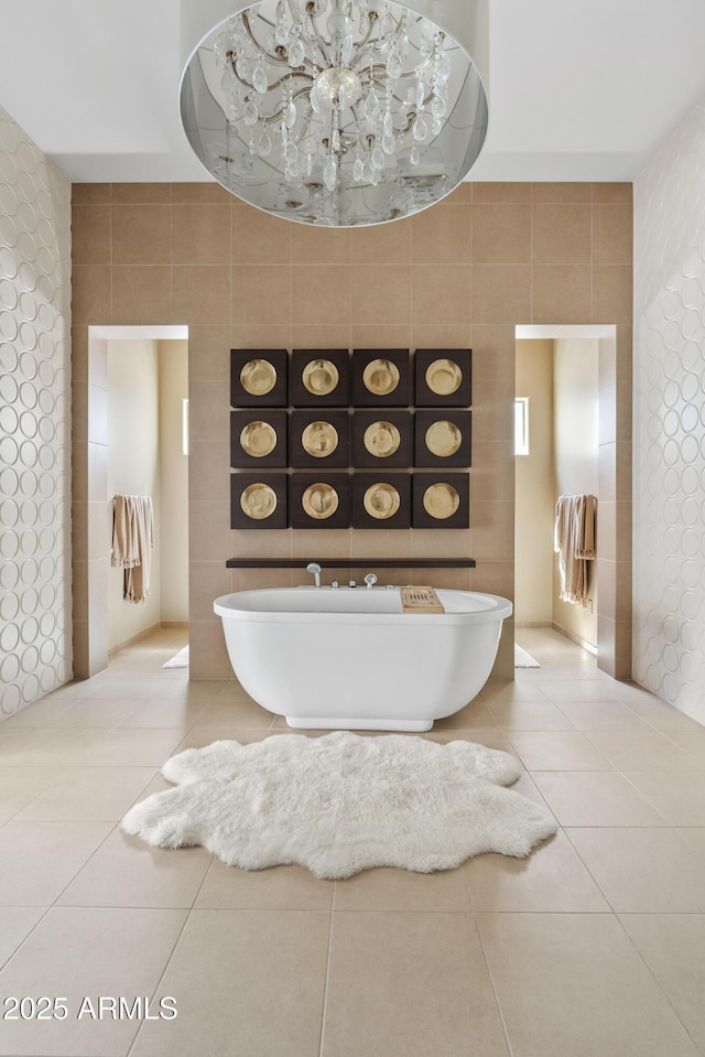 full bath with tile patterned floors, a freestanding tub, and tile walls