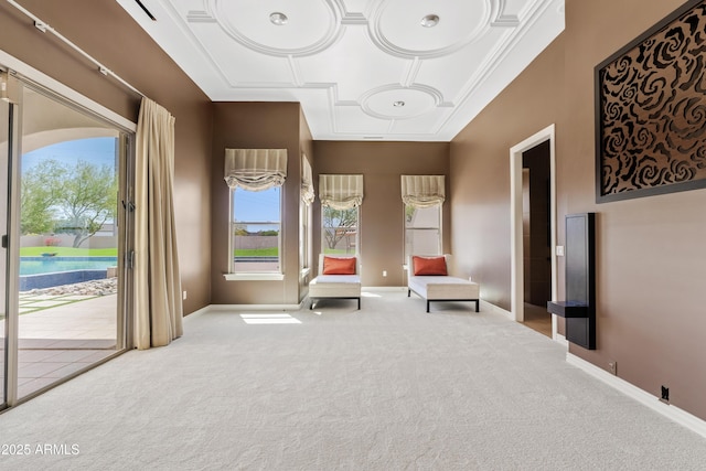 sitting room with a wealth of natural light, carpet, and baseboards