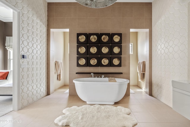 bathroom with tile patterned floors, a soaking tub, and tile walls