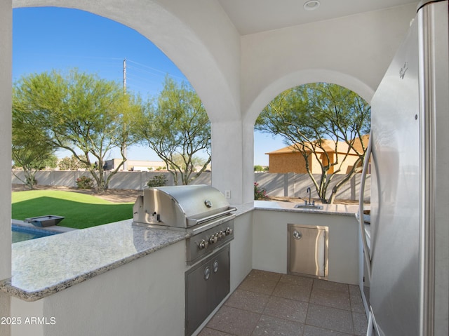 view of patio / terrace featuring exterior kitchen, grilling area, a fenced backyard, and a sink