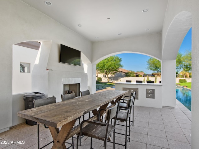 view of patio / terrace with an outdoor pool, an outdoor fireplace, and outdoor wet bar