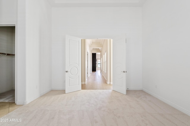 unfurnished bedroom featuring a spacious closet, baseboards, and carpet flooring