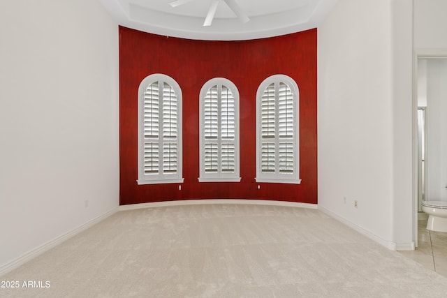 unfurnished room with carpet floors, baseboards, and a ceiling fan