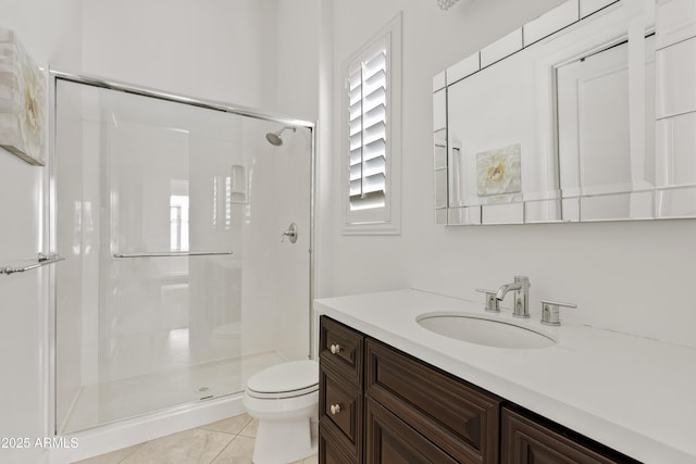 bathroom featuring a shower stall, vanity, toilet, a healthy amount of sunlight, and tile patterned floors