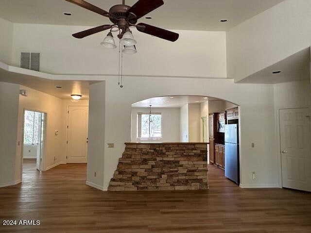 interior space featuring ceiling fan, a high ceiling, plenty of natural light, and hardwood / wood-style flooring