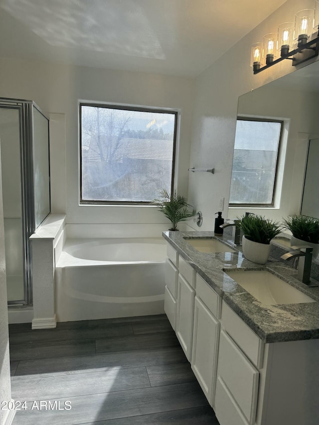 bathroom featuring hardwood / wood-style flooring, vanity, and plus walk in shower