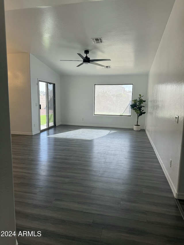 unfurnished room featuring dark hardwood / wood-style flooring, vaulted ceiling, and ceiling fan