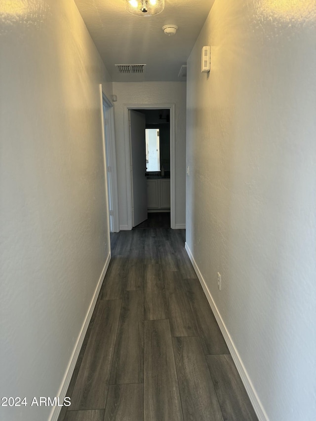 corridor with dark hardwood / wood-style flooring