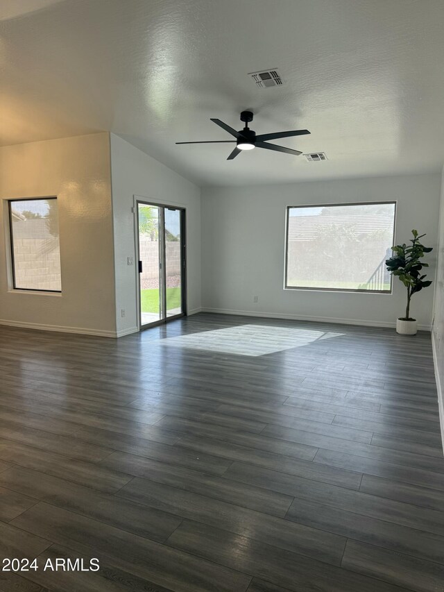 spare room with dark wood-type flooring, plenty of natural light, lofted ceiling, and ceiling fan