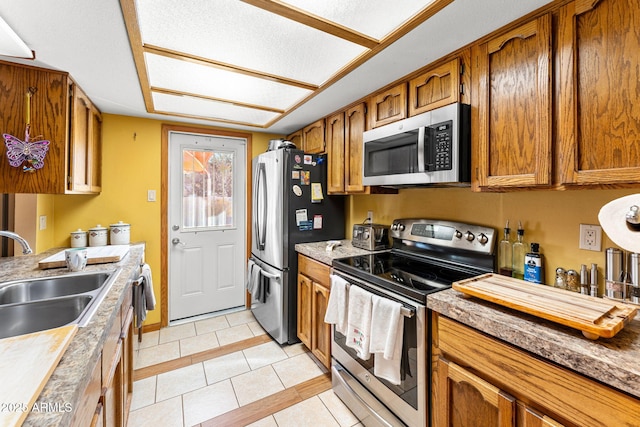 kitchen with sink, light tile patterned floors, and stainless steel appliances