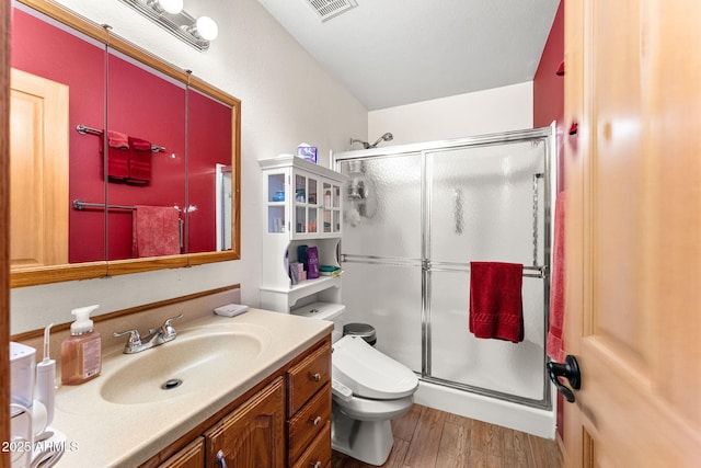 bathroom with toilet, a shower with door, vanity, and hardwood / wood-style flooring