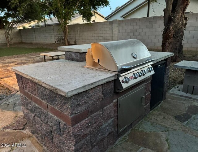 view of patio with an outdoor kitchen and a grill