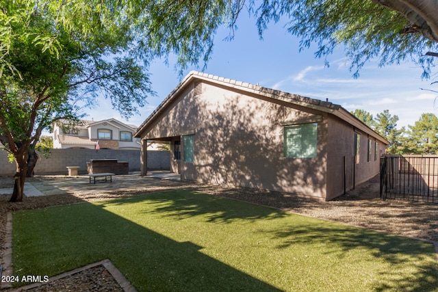 rear view of house with a lawn and a patio