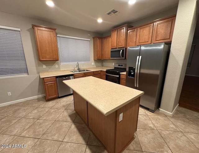 kitchen featuring light tile patterned flooring, sink, a kitchen island, and stainless steel appliances