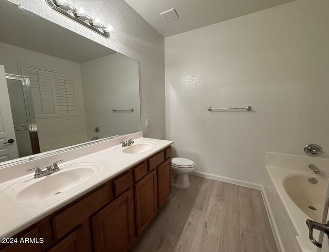 full bathroom with hardwood / wood-style flooring, vanity, toilet, and shower with separate bathtub