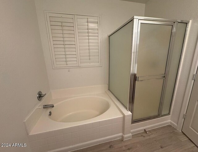 bathroom with hardwood / wood-style floors and shower with separate bathtub