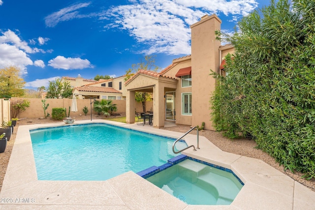 view of pool featuring a patio, a fenced backyard, and a pool with connected hot tub