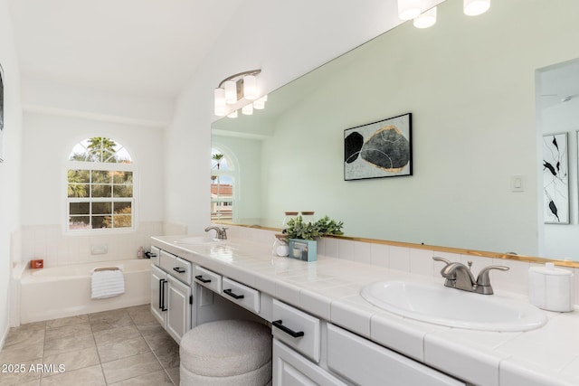 full bathroom with double vanity, a sink, a bath, and tile patterned floors