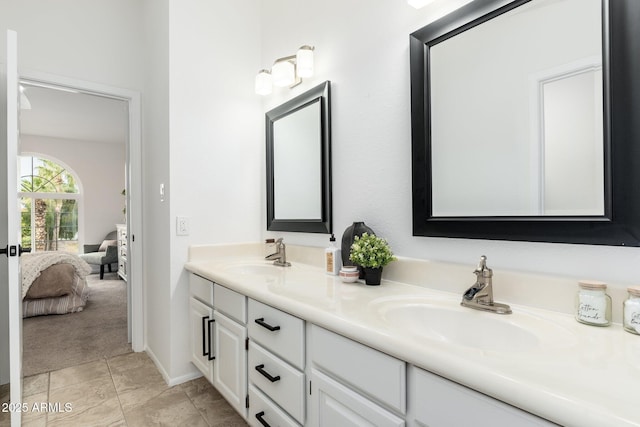 ensuite bathroom featuring double vanity, ensuite bath, and a sink