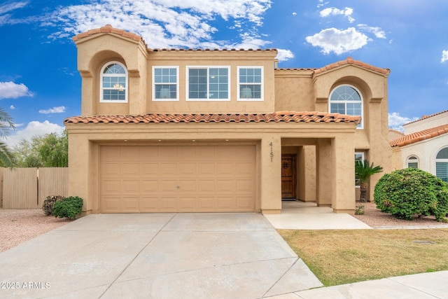 mediterranean / spanish-style home with driveway, an attached garage, fence, and stucco siding