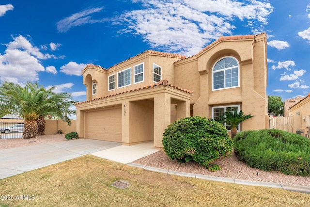 mediterranean / spanish home with a garage, concrete driveway, fence, and stucco siding