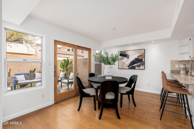 dining space with light wood-type flooring, baseboards, and recessed lighting