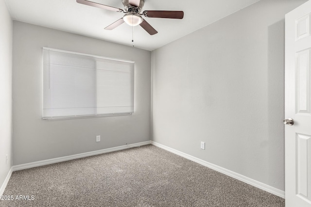 carpeted empty room with ceiling fan and baseboards