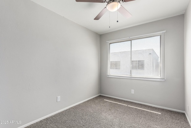 carpeted empty room featuring baseboards and a ceiling fan