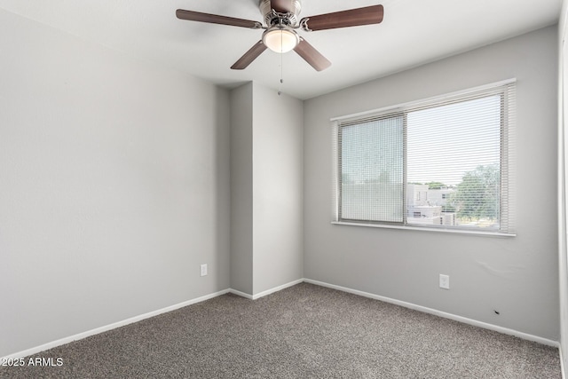 carpeted spare room with baseboards and a ceiling fan