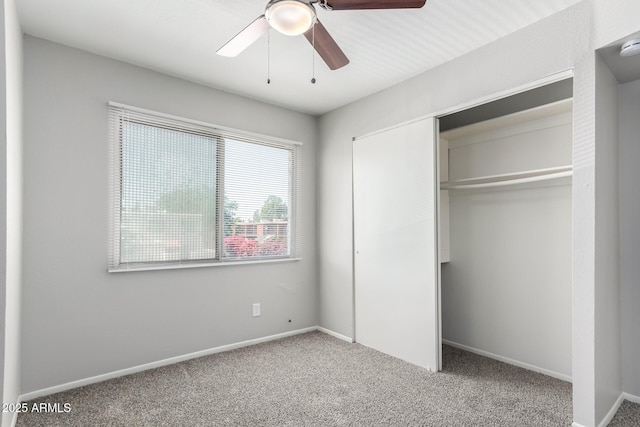 unfurnished bedroom with ceiling fan, a closet, baseboards, and carpet floors