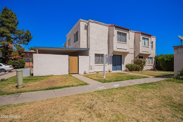 view of property featuring a front yard, fence, a gate, and stucco siding