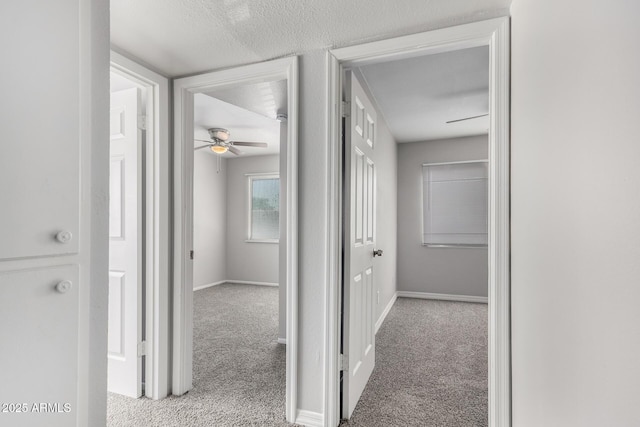 corridor with baseboards and carpet floors
