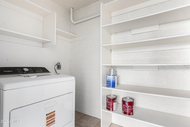 clothes washing area featuring washer / clothes dryer, tile patterned floors, and laundry area