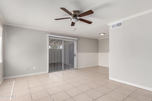 spare room with ornamental molding, a ceiling fan, visible vents, and light tile patterned floors