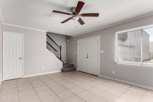 entryway with ornamental molding, baseboards, a ceiling fan, and stairway