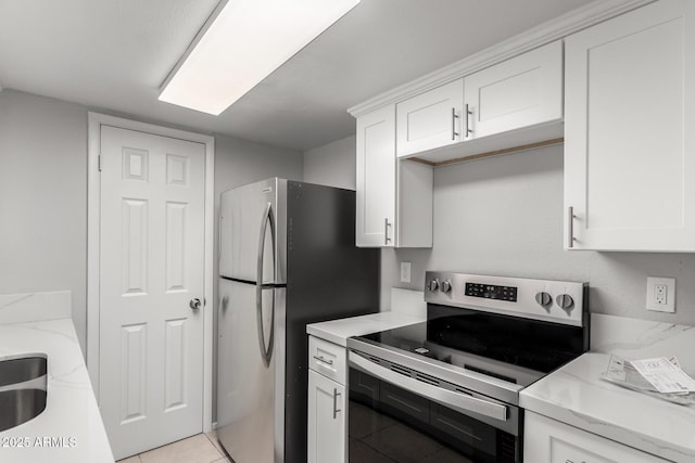 kitchen featuring stainless steel electric range, light tile patterned floors, white cabinetry, and light stone countertops