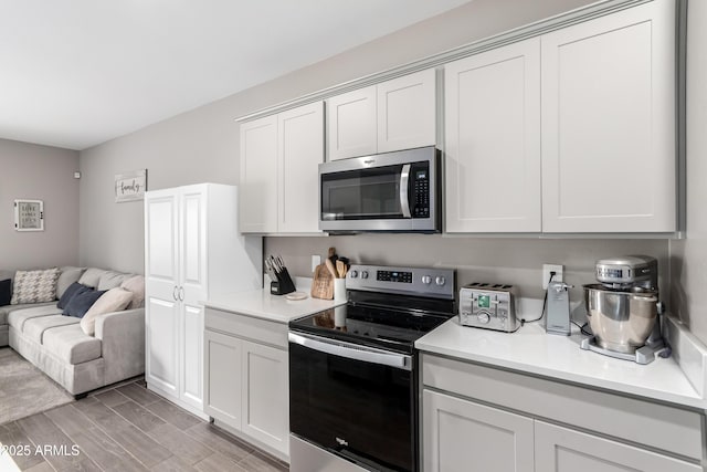 23934 W Verlea Dr, Buckeye, AZ 85326 - kitchen featuring stainless steel appliances, open floor plan, light countertops, and white cabinetry