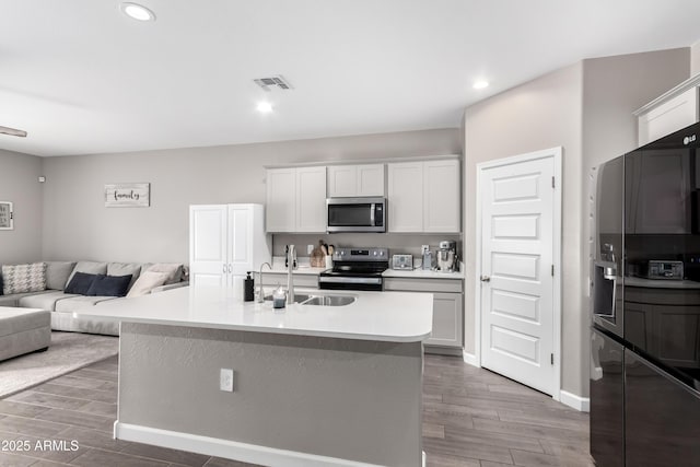 23934 W Verlea Dr, Buckeye, AZ 85326 - kitchen with stainless steel appliances, a sink, open floor plan, wood finished floors, and recessed lighting
