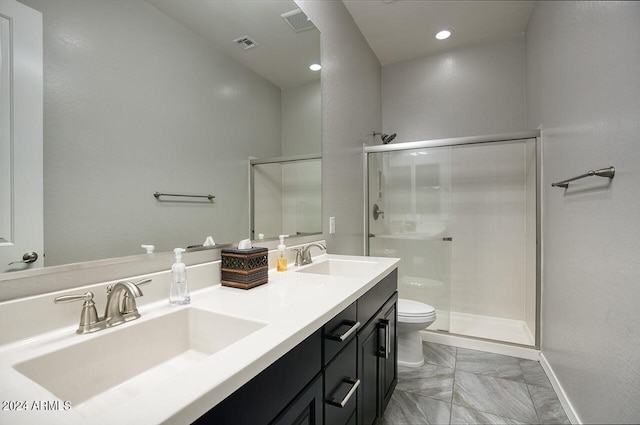 bathroom with toilet, a shower with door, and vanity