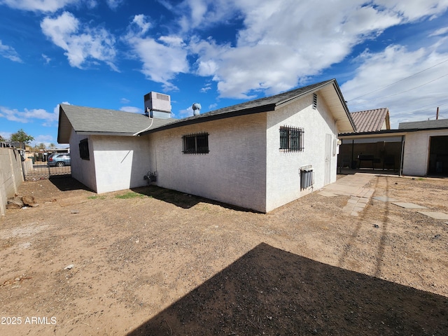 back of property with fence and stucco siding