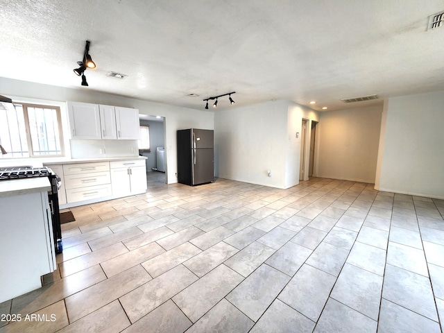 3123 W Holly St, Phoenix, AZ 85009 - kitchen with visible vents, range with gas stovetop, white cabinetry, freestanding refrigerator, and light countertops