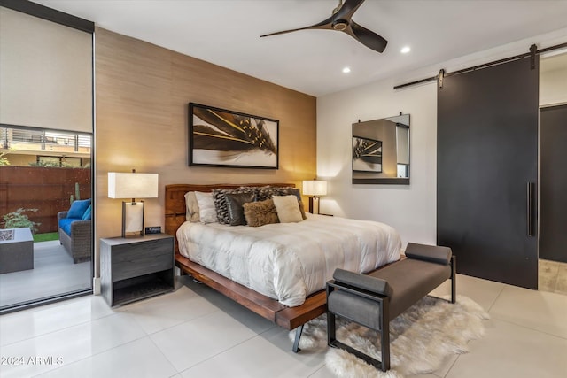 bedroom featuring a barn door, ceiling fan, light tile patterned floors, and access to exterior