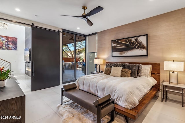 tiled bedroom with ceiling fan, a barn door, floor to ceiling windows, and access to outside