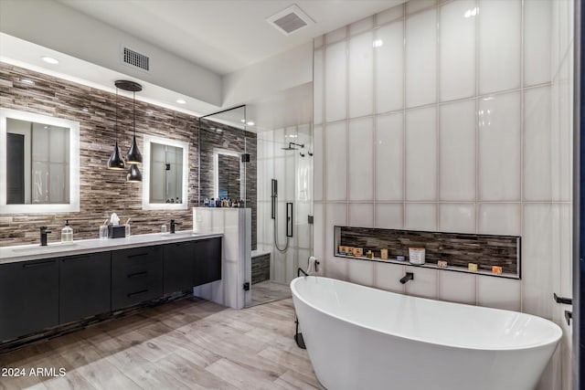 bathroom featuring separate shower and tub, tasteful backsplash, vanity, and tile walls