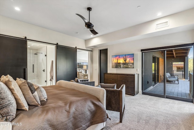 bedroom with light carpet, access to outside, ceiling fan, a barn door, and connected bathroom